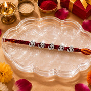 Silver Om Rakhi – Sacred Om Charm on Handwoven Maroon Thread
