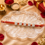 Silver Swastik Rakhi – Sacred Swastik Charm on Traditional Red Thread